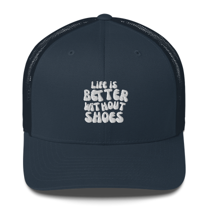 Navy blue cap with 'Life is Better Without Shoes' text on a white background